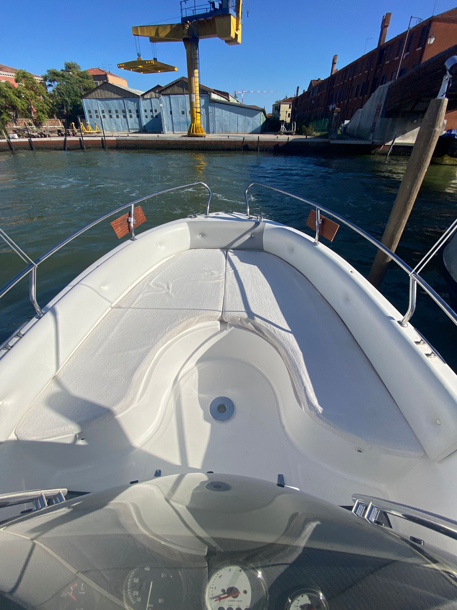Bow area of the Venetian Boat with white cushions and handrails, viewed from the steering position