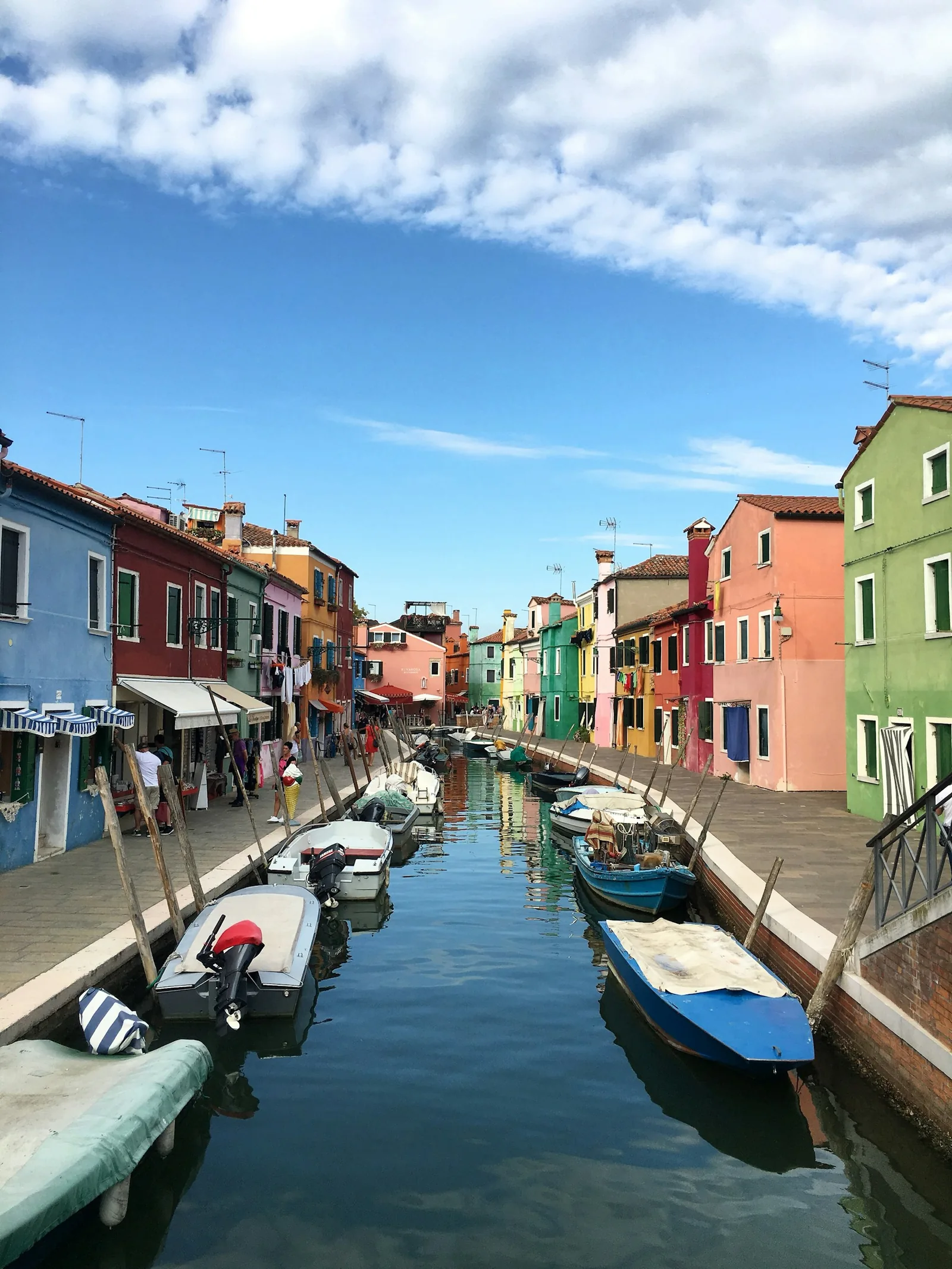 Colourful houses and a canal in Burano under a blue sky