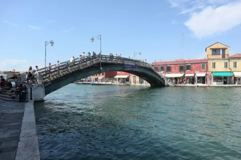 Ponte e case lungo un canale di Murano