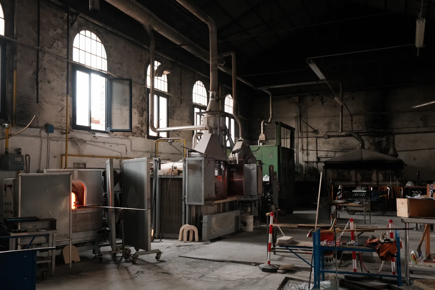 Inside a Murano glass factory with furnaces and tools; illustrative photograph, not of the factory visited