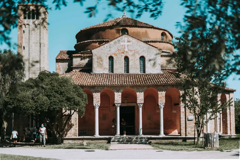 A historic church and trees in Torcello’s square