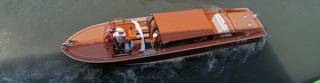 Wooden Venetian Water Taxi underway, seen from above with the skipper at the helm